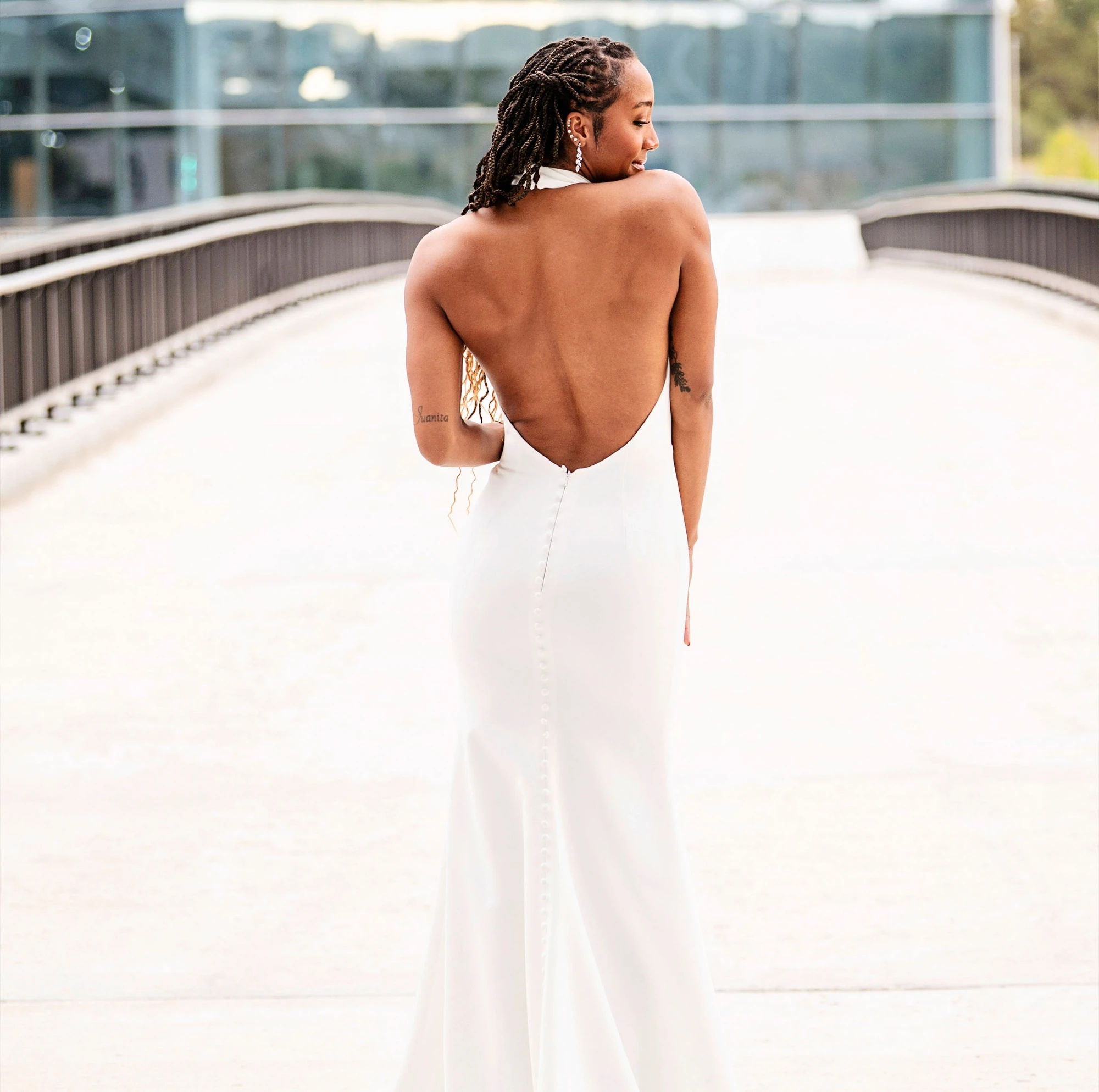 Model wearing a low back wedding dress